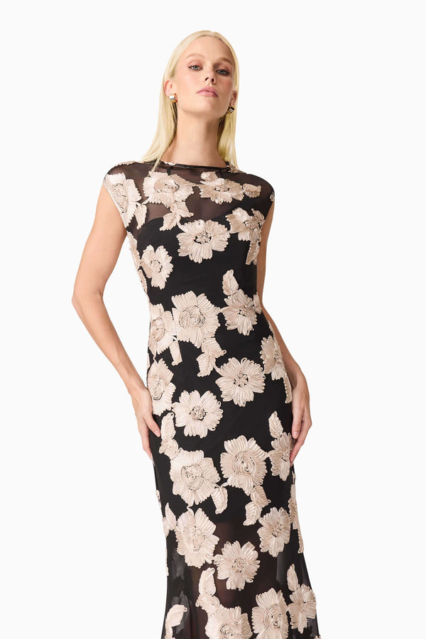 Blonde model wearing Margaus Fit & Flare Gown in Black & Gold Floral close up shot