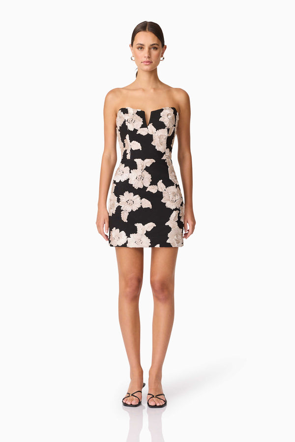 Brunette model wearing Margaux Strapless Mini Dress in Black & Gold Floral  front shot