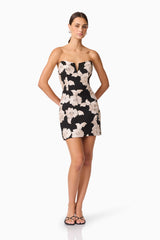 Brunette model wearing Margaux Strapless Mini Dress in Black & Gold Floral  posed shot