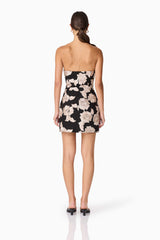 Brunette model wearing Margaux Strapless Mini Dress in Black & Gold Floral  back shot