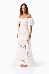 Brunette model wearing the Roxana Off The Shoulder Gown in White side shot 