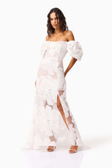 Brunette model wearing the Roxana Off The Shoulder Gown in White posed hands behind hip shot 