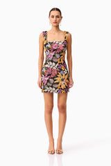 Brunette model wearing the Kiran Party Mini Dress in Orange Floral front shot 
