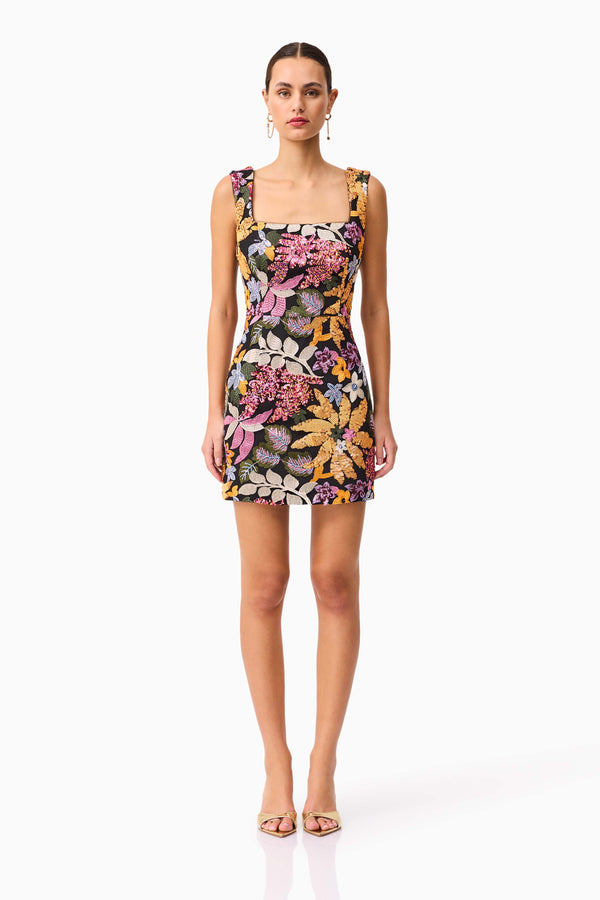 Brunette model wearing the Kiran Party Mini Dress in Orange Floral front shot 