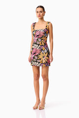 Brunette model wearing the Kiran Party Mini Dress in Orange Floral side shot 