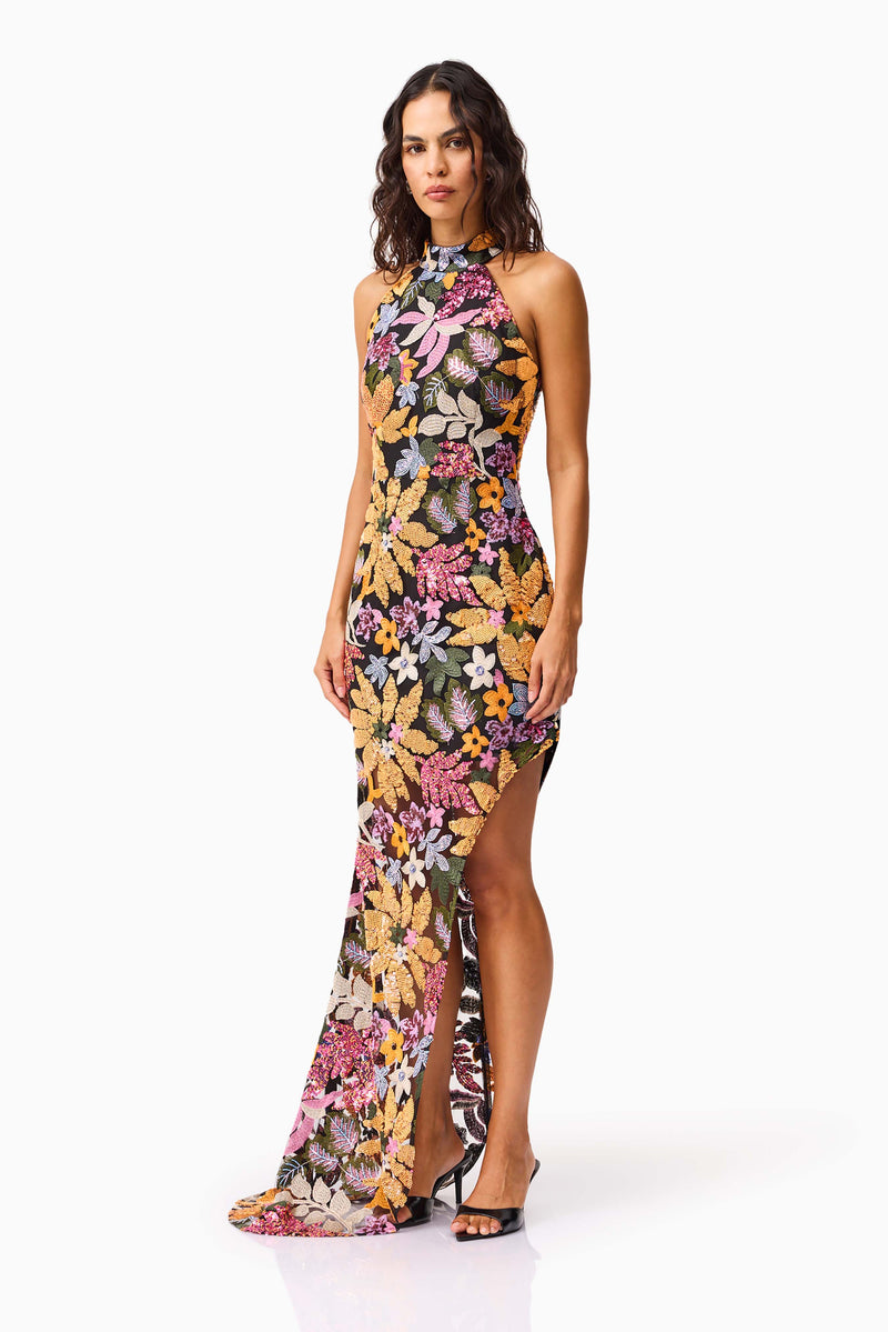 Brunette model wearing the Kiran Halter Gown in Orange Floral side shot 