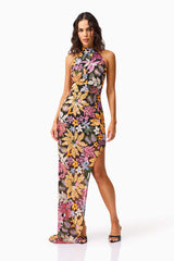 Brunette model wearing the Kiran Halter Gown in Orange Floral posed shot 