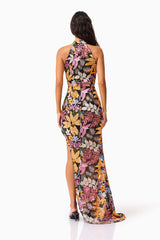 Brunette model wearing the Kiran Halter Gown in Orange Floral back shot 