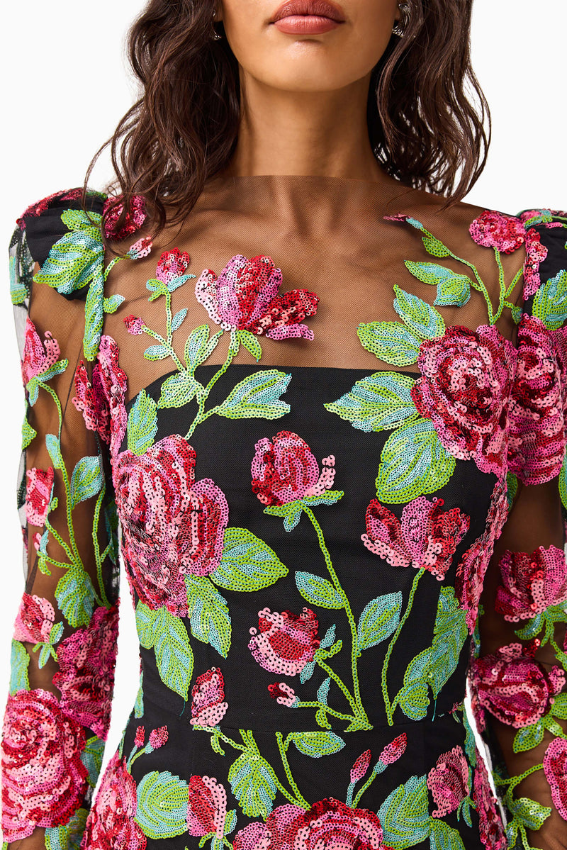 Brunette model wearing the Lyra Sequin Long Sleeve Midi Dress in Pink & Green Floral detail shot