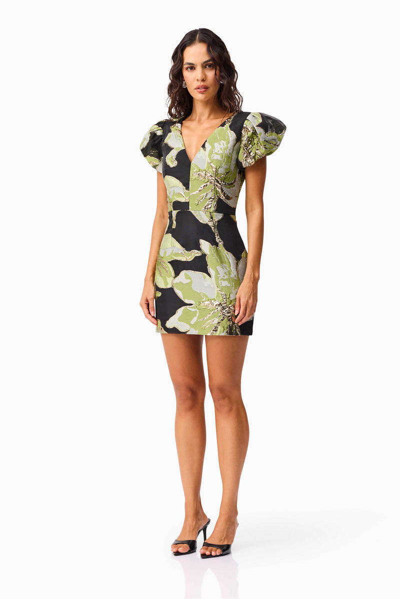 Brunette model wearing the Elysia Cap Sleeve Mini Dress in Black & Green Floral side shot