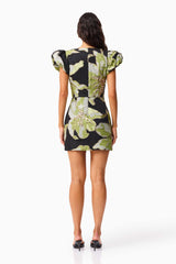 Brunette model wearing the Elysia Cap Sleeve Mini Dress in Black & Green Floral back shot