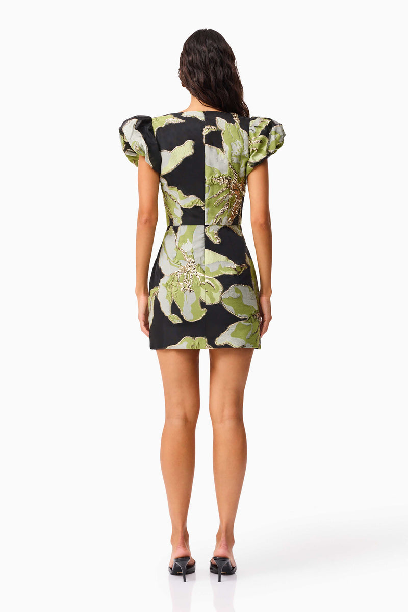 Brunette model wearing the Elysia Cap Sleeve Mini Dress in Black & Green Floral back shot