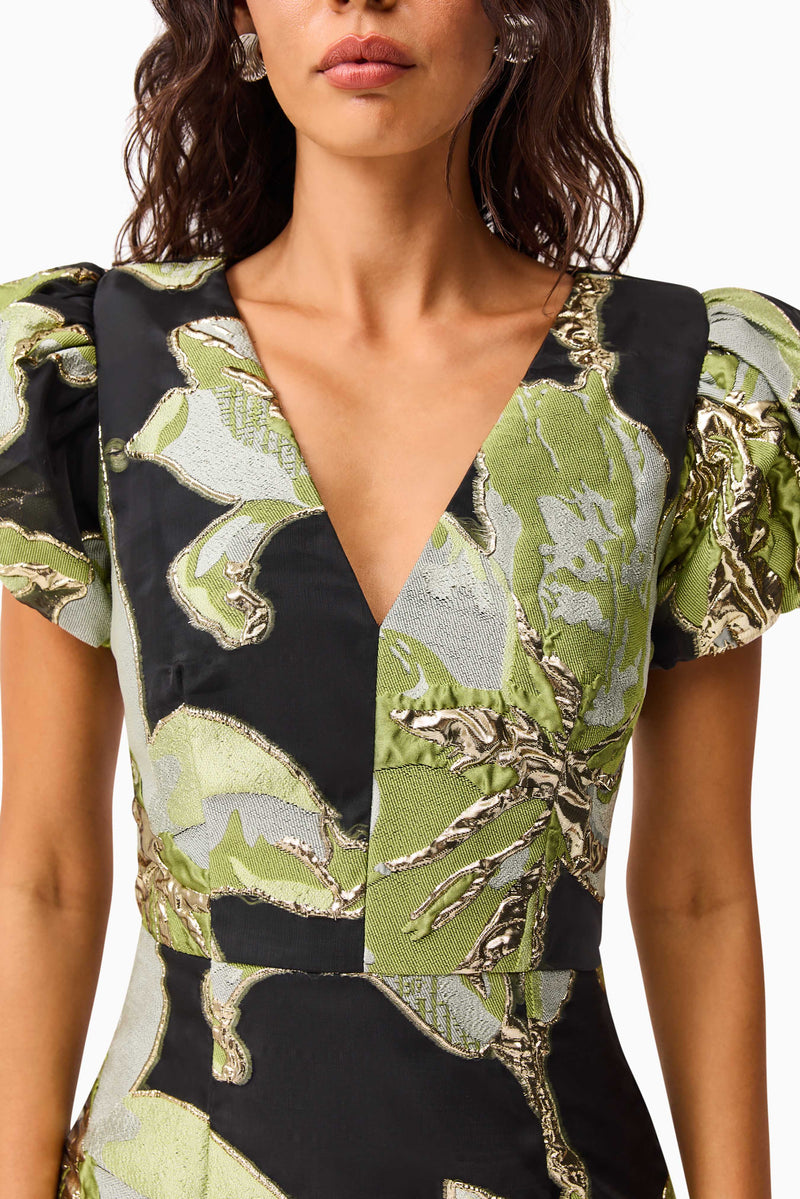 Brunette model wearing the Elysia Cap Sleeve Mini Dress in Black & Green Floral detail shot