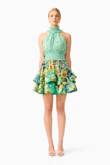 Blonde model wearing the Estelle Halter Mini Dress in Green Floral front shot