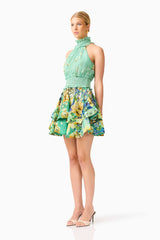 Blonde model wearing the Estelle Halter Mini Dress in Green Floral side shot