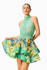Blonde model wearing the Estelle Halter Mini Dress in Green Floral close up posed shot