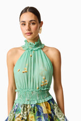 Blonde model wearing the Estelle Halter Mini Dress in Green Floral close up shot