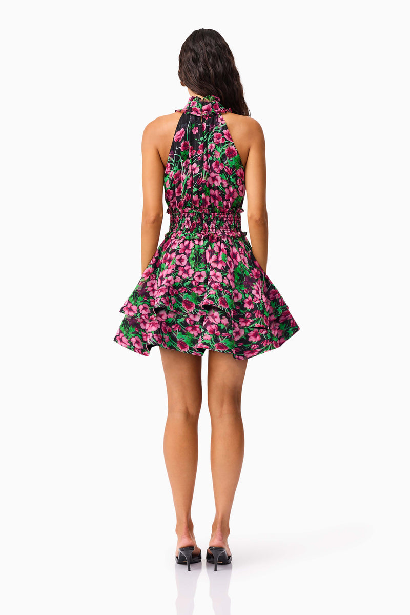 Brunette Model wearing the Estelle Halter Mini Dress in Black & Pink Floral back shot
