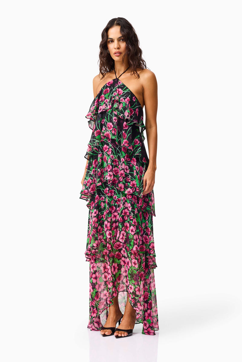 Brunette model wearing the Estelle Halter Gown in Black & Pink Floral side shot