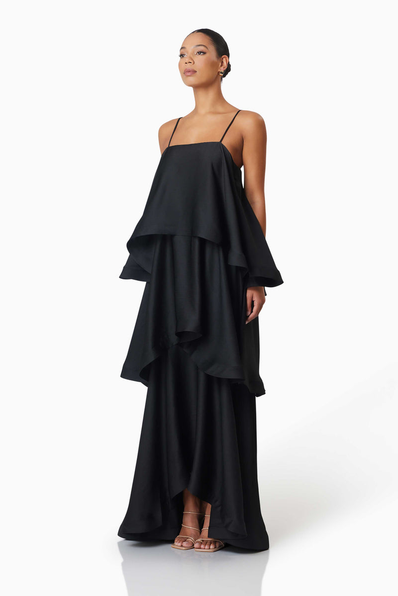 Brunette model wearing Tilly Tiered Maxi Dress in Black side shot