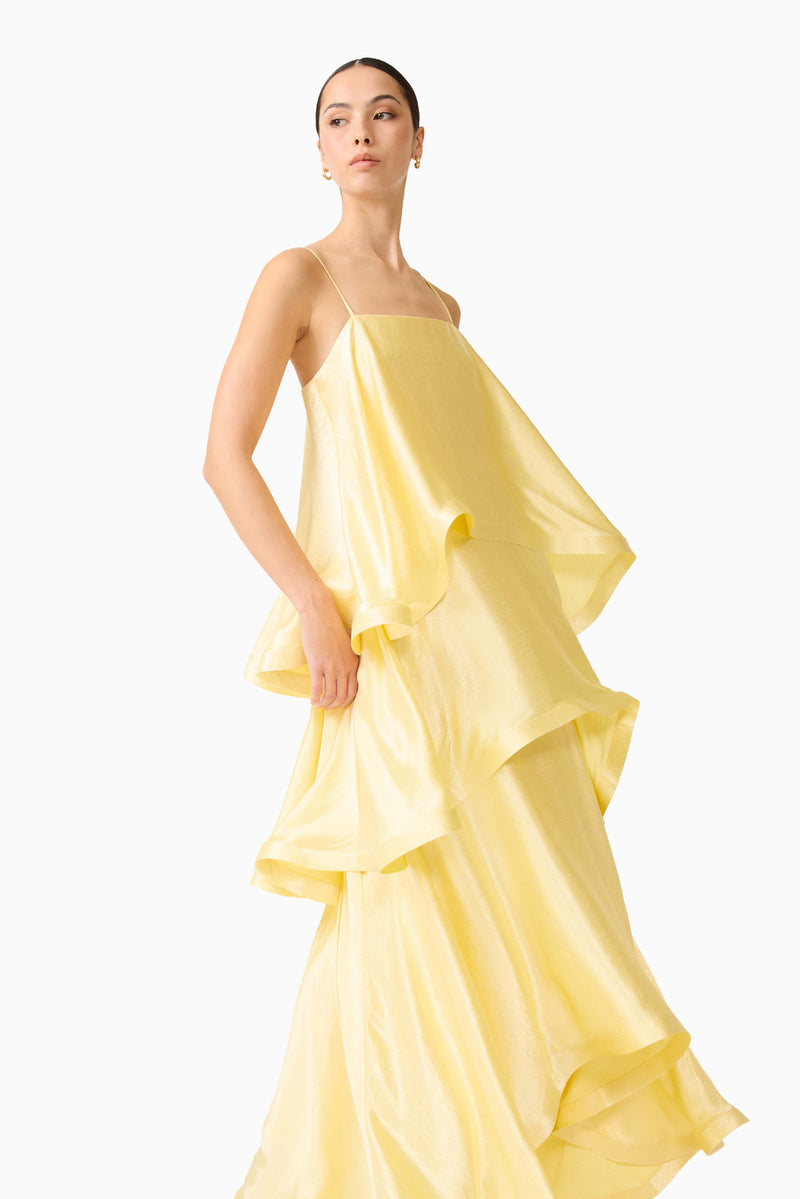 Brunette model wearing the Tilly Tiered Maxi Dress in Butter Yellow posed looking away  shot
