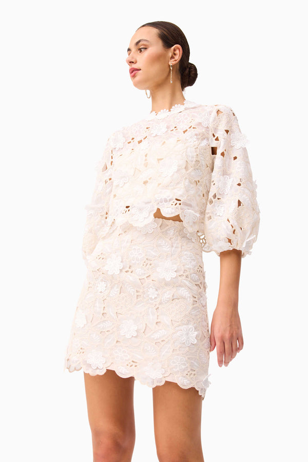 Brunette model wearing the Sienna Short Sleeve Top & Mini Skirt Set in Cream close up shot