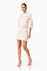 Brunette model wearing the Sienna Short Sleeve Top & Mini Skirt Set in Cream posed shot