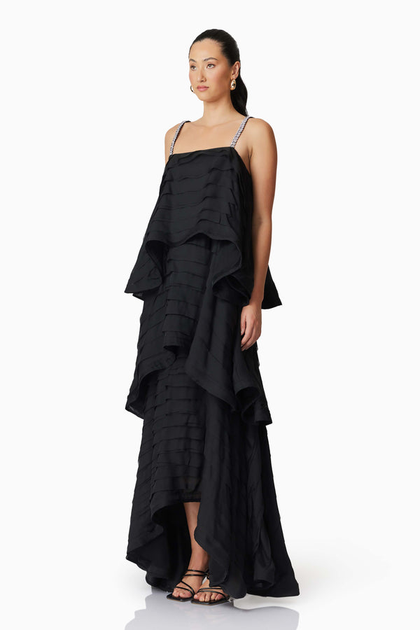Brunette model wearing Eira Tiered Maxi Dress in Black side shot