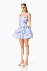 Brunette model wearing the Elin A-Line Mini Dress in Blue Floral side shot