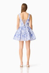 Brunette model wearing the Elin A-Line Mini Dress in Blue Floral back shot