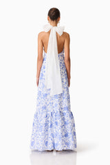 Brunette model wearing the Elin Halter Gown in Blue Floral back shot