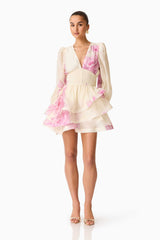 Brunette model wearing the Rova Long Sleeve Mini Dress in Cream & Pink Floral posed front shot