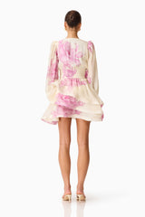 Brunette model wearing the Rova Long Sleeve Mini Dress in Cream & Pink Floral back shot