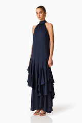 Brunette model wearing the Varella Halter Gown in Navy side shot