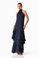 Brunette model wearing the Varella Halter Gown in Navy posed side shot