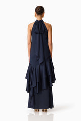 Brunette model wearing the Varella Halter Gown in Navy back shot