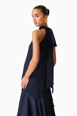 Brunette model wearing the Varella Halter Gown in Navy posed back shot