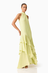 Brunette model wearing the Varella Halter Gown in Pistachio Green posed side shot 