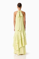 Brunette model wearing the Varella Halter Gown in Pistachio Green back shot 