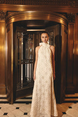 Brunette model wearing the Vessia Halter Neck Maxi Dress in Cream campaign shot