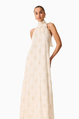 Brunette model wearing the Vessia Halter Neck Maxi Dress in Cream close up shot