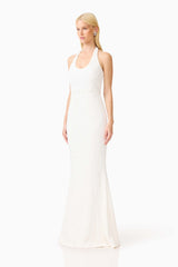 Brunette model wearing the Alexandra Halter Gown Dress in White side shot 
