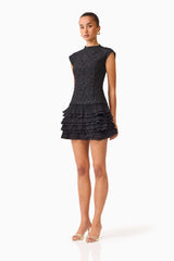 Brunette model wearing the Alexandra Tiered Mini Dress in Black side shot 
