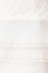 Brunette model wearing the Alexandra Tiered Mini Dress in White detail shot