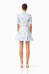 Brunette model wearing the Kalissa A-Line Mini Dress in Blue Floral back shot 