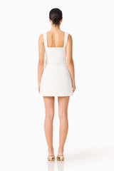 Brunette model wearing the Nydia Tulip Mini Dress in White back shot