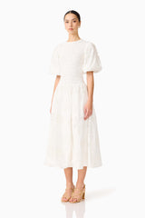 Brunette model wearing the Celine Puff Sleeve Maxi Dress in White side shot 