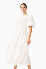 Brunette model wearing the Celine Puff Sleeve Maxi Dress in White close up shot 