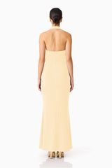 Brunette model wearing the 
Simone Cowl Neck Gown in Butter Yellow back shot