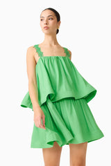 Brunette model wearing the Emilie Tiered mini Dress in Kelly Green close up shot